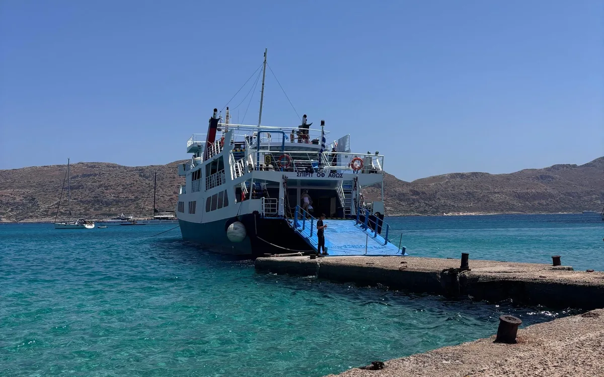 A passenger boat moored at a small concrete jetty on Gramvousa